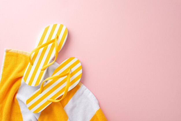 Foto minimal conceito de itens essenciais de férias de moda vista superior de toalha plana de chinelos listrados amarelos em fundo rosa pastel com espaço vazio para texto ou anúncio