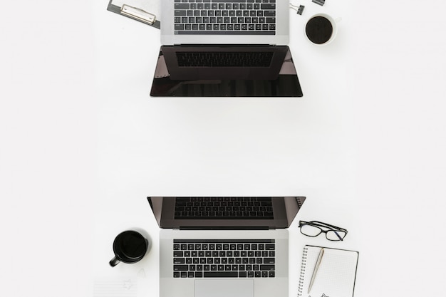 Minimale freiberufliche Büroarbeitsplatzebene legen Draufsicht Worksplase mit Laptopnotizbuchstiftglas-Kaffeetasse