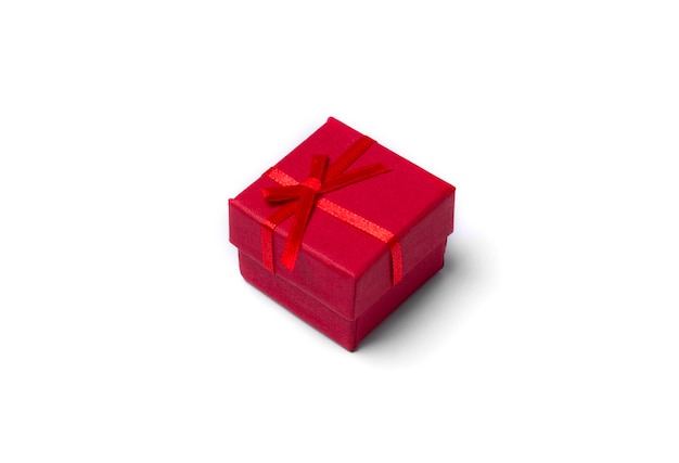 Minimale Komposition mit roter Weihnachtsgeschenkbox am weißen Tisch