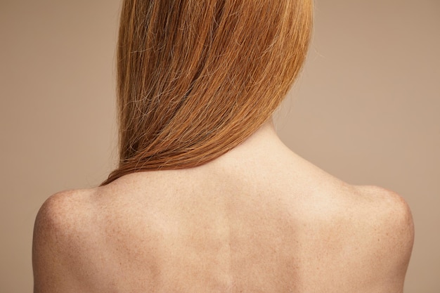 Minimale Rückansicht einer sommersprossigen rothaarigen Frau mit nackten Schultern Kopienraum