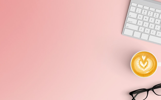 Minimaler Arbeitsplatz mit Kaffeetasse und Tastatur auf rosa Farbe
