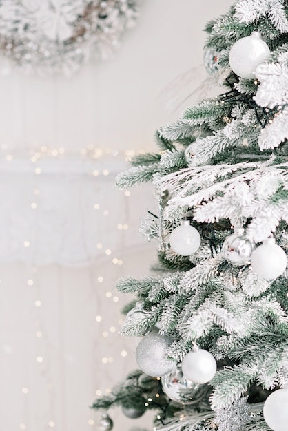 Foto minimaler weihnachtshintergrund, ein weihnachtsbaum, der mit kugeln auf einem hintergrund von verschwommenen bokeh-lichtern verziert wird
