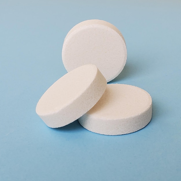 Minimalismo macro três pílulas em um fundo azul copyspace medicina tratamento de doenças