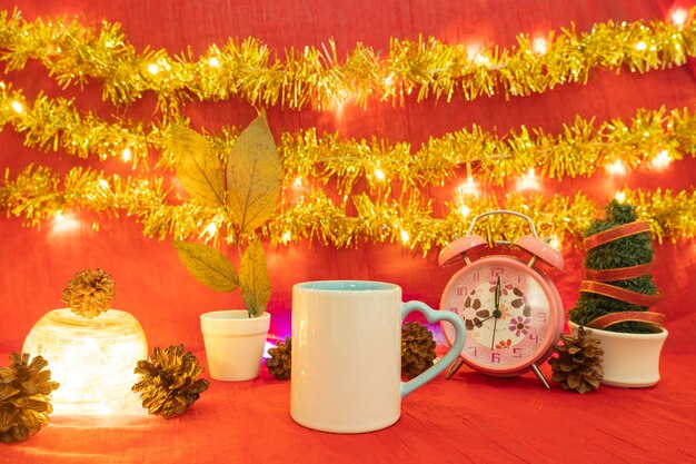 Minimalistische Konzeptidee, die Produkte anzeigt. Kaffeetasse auf Weihnachten und Neujahr background.red, Lichter, Kiefernblumen