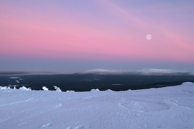 Minimalistische natürliche Winterlandschaft Kalter Vollmond über einem schneebedeckten nebligen Abhang Polarnachtslandschaft im Winter Kaltes Winterwetter Raues nördliches Klima