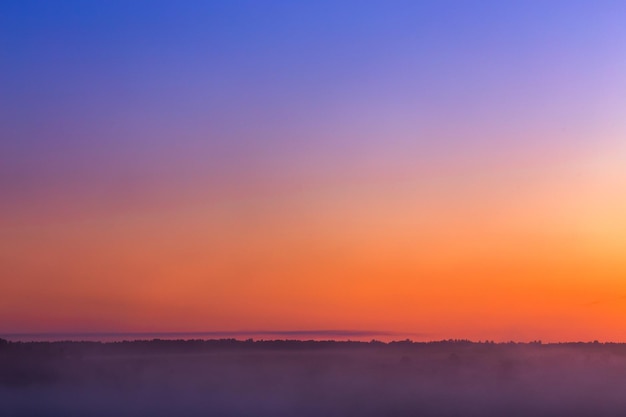 Minimalistischer nebliger Himmel leuchtet vor Sonnenaufgang ohne Sonne