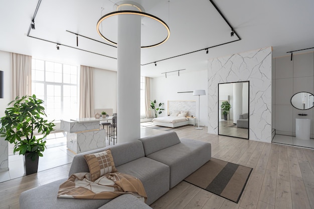 Minimalistisches, modernes Luxusdesign eines teuren Hauses mit Marmorverkleidung an einem sonnigen Tag, weißen Wänden mit dekorativer Beleuchtung aus Gipsparkett und niemand drinnen