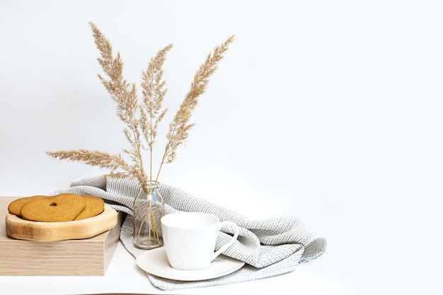 Minimalistisches Stillleben mit Pampasgras Tasse Kaffee und herzförmigem Lebkuchen