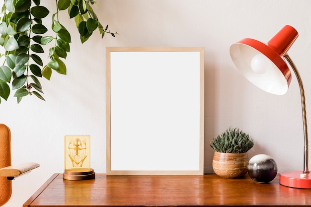 Minimalistisches und stilvolles Posterrahmenkonzept mit Retro-Möbeln, Hängepflanze, Tischlampe, Dekoration und eleganten Accessoires. Weisse Wände. Vorlage.