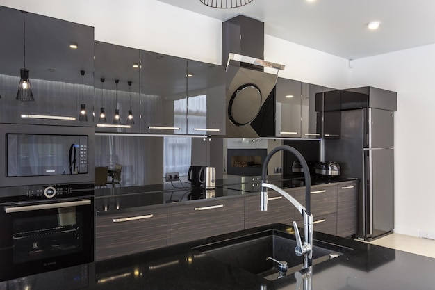 MINSK BIELORRÚSSIA JANEIRO DE 2019 Interior da cozinha moderna e salão de hóspedes em loft em estilo minimalista com cor preta
