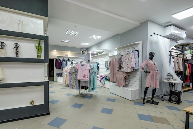 MINSK BIELORRUSIA ABRIL 2020 interior de la tienda de ropa y zapatos de mujer de moda con telas de estantes en los grandes almacenes textiles de élite y souvenirs