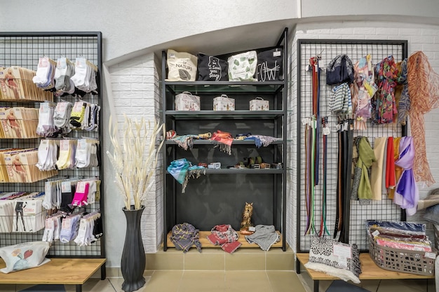 MINSK BIELORRUSIA ABRIL 2020 interior de la tienda de ropa y zapatos de mujer de moda con telas de estantes en los grandes almacenes textiles de élite y souvenirs