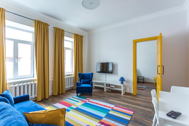 MINSK BIELORRUSIA Marzo de 2019 interior retro brillante de apartamentos hipster con sofá azul puerta amarilla y alfombra de color