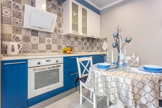 MINSK BIELORRUSIA SEPTIEMBRE 2019 Interior de la moderna cocina de lujo con mesa de invitados en apartamentos tipo estudio de estilo minimalista con color azul