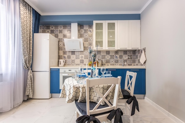 MINSK WEISSRUSSLAND SEPTEMBER 2019 Interieur der modernen Luxusküche mit Gästetisch in Studio-Apartments im minimalistischen Stil mit blauer Farbe