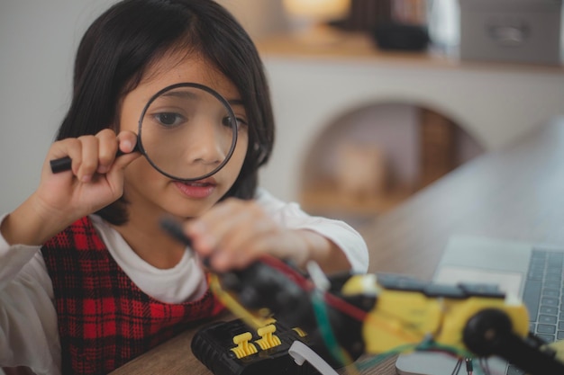 MINT-Bildungskonzept Asiatische Schüler lernen zu Hause, indem sie Roboterarme in MINT-Mathematik, Ingenieurwesen, Wissenschaftstechnologie, Computercode in Robotik für Kinderkonzepte programmieren