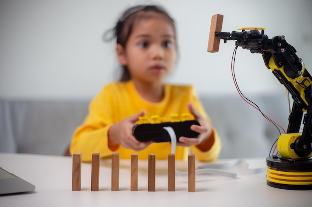 MINT-Bildungskonzept Asiatische Schüler lernen zu Hause, indem sie Roboterarme in MINT-Mathematik, Ingenieurwesen, Wissenschaftstechnologie, Computercode in Robotik für Kinderkonzepte programmieren