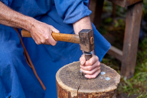 Foto minter medieval cunhando uma moeda