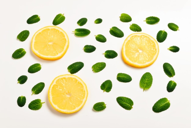 Minzblätter und Zitronenscheiben auf weißem Hintergrund
