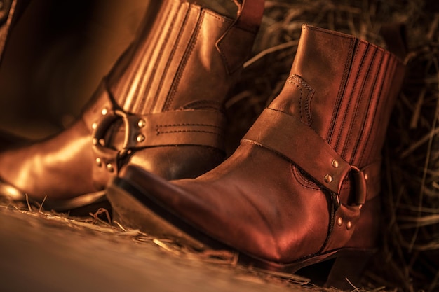 Mira las botas de cuero de vaquero occidentales en el granero Foto de primer plano