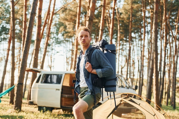 Mira la ubicación El hombre viaja solo en el bosque durante el día en verano