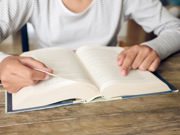 Mirada de cerca de una niña leyendo un libro, no se muestran caras