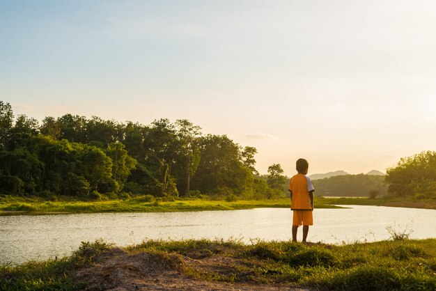 Mirada del niño en el río a la luz del sol