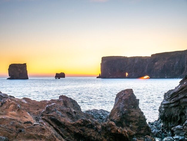 Mirador del arco de Dyrholaey cerca de la ciudad de Vik en el sur de Islandia durante el crepúsculo del cielo vespertino a lo largo de la costa