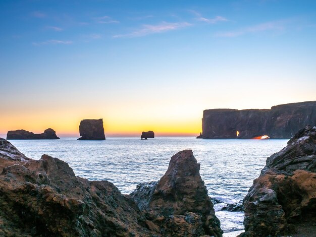 Mirador del arco de Dyrholaey cerca de la ciudad de Vik en el sur de Islandia durante el crepúsculo del cielo vespertino a lo largo de la costa