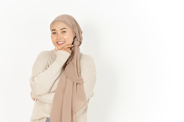 Mirando a la cámara y la sonrisa de la hermosa mujer asiática vistiendo Hijab aislado sobre fondo blanco.