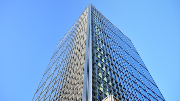 Mirando hacia un edificio alto con un cielo azul claro en el fondo.