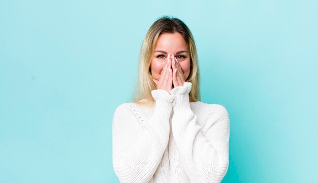 Mirando feliz alegre afortunado y sorprendido cubriendo la boca con ambas manos