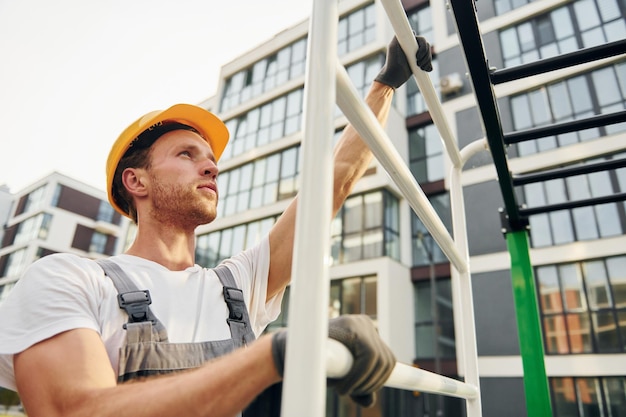 Mirando lejos Joven trabajando en uniforme en la construcción durante el día