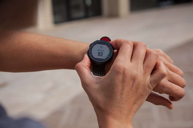 Foto mirando el reloj inteligente en la cinta de correr corriendo en el concepto de gimnasio concepto de estilo de vida activo