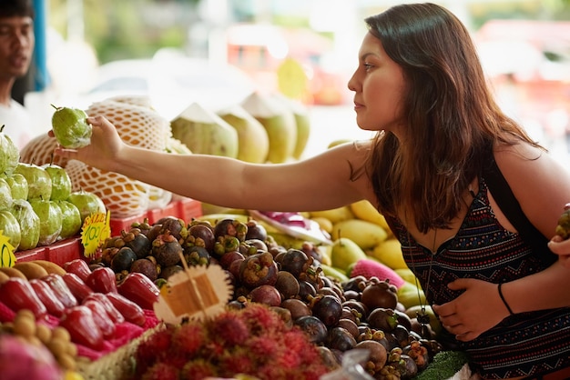 Mirando la tienda de comestibles local Foto de una mujer joven y atractiva mirando fruta en una tienda de comestibles extranjera