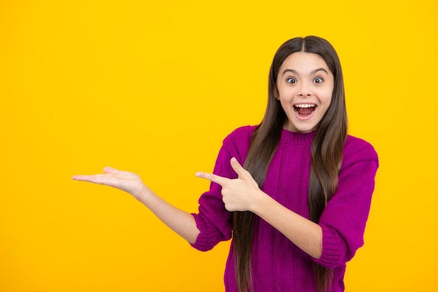 Mire el anuncio Los puntos del niño adolescente a un lado muestran el espacio en blanco para la presentación de la idea de promoción de texto posa contra el fondo amarillo