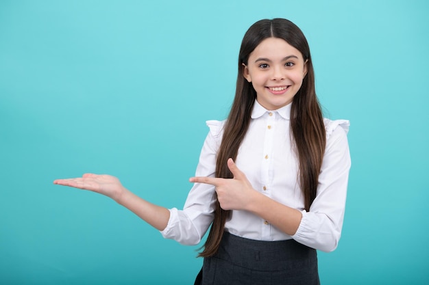 Mire el anuncio Los puntos del niño adolescente a un lado muestran el espacio en blanco para la presentación de la idea de promoción de texto posa contra el fondo azul