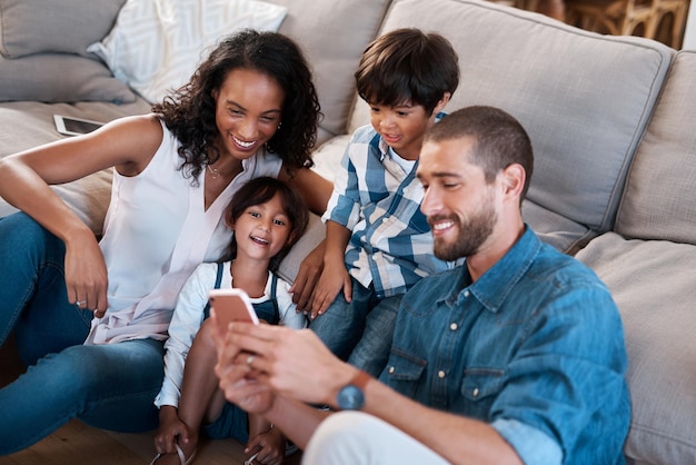 Mire esta foto de una familia de cuatro viendo algo en un teléfono celular.