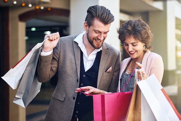 Mire todos los artículos que tengo Foto de una mujer mostrándole a su novio lo que compró mientras estaba de compras