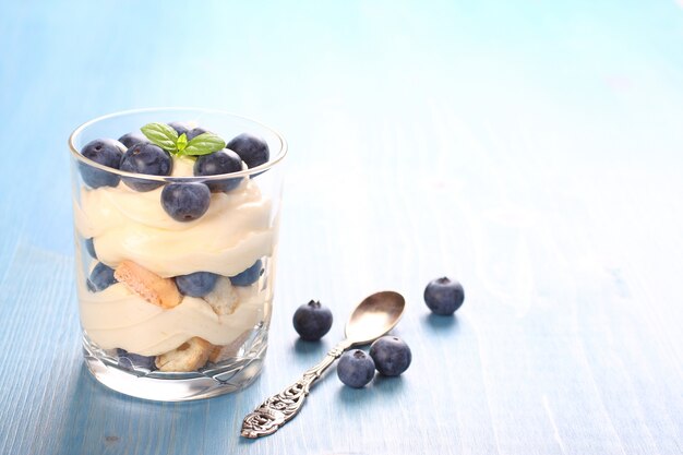 Mirtilo fresco mergulhado deserto com creme de mascarpone e biscoitos em vidro