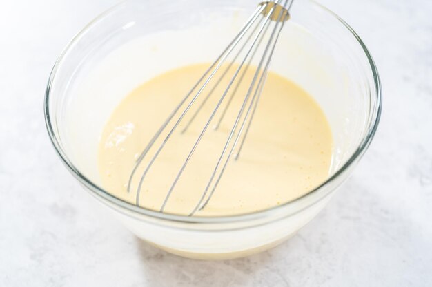 Mischen der Zutaten in einer Rührschüssel aus Glas, um den Bundt-Kuchen mit Schokoladensternen am 4. Juli zu backen.