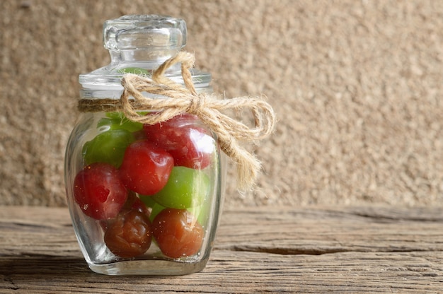 Foto mischen sie essiggurkenkirschfrucht in der glasflasche auf holztisch