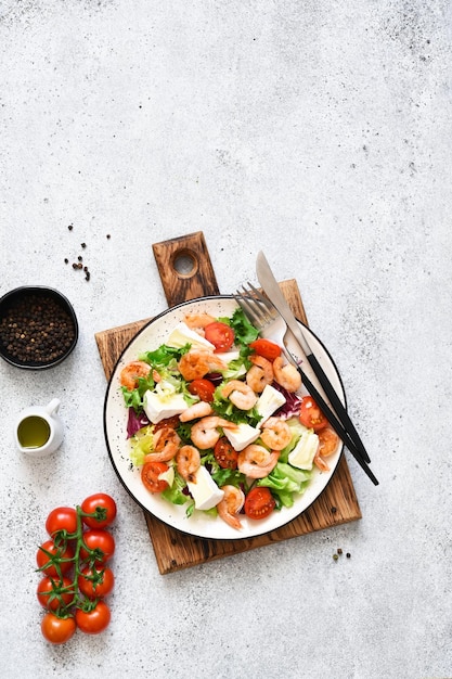 Foto mischen sie salat mit käsebrie und garnelen auf einer betonhintergrund-draufsicht