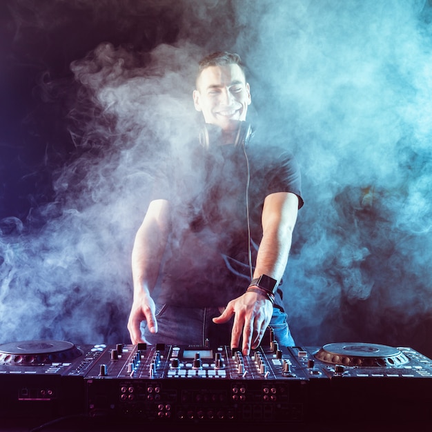 Mischende Musik DJ auf Mischer auf dunklem Hintergrund
