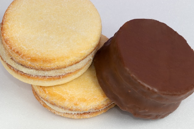 Mischung aus Alfajores mit Schokolade überzogen und gefüllt mit Dulce de Leche auf weißem Hintergrund.