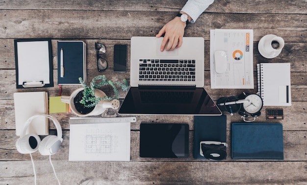 Mischung aus Büromaterial und Gadgets auf einem hölzernen Schreibtisch