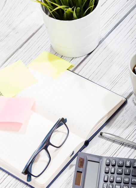 Mischung aus Büromaterial und Gadgets auf einem Holztisch