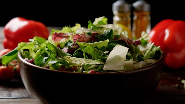 Foto mischung aus frischem grünem salat in einem teller auf dem tisch mit gemüse und gewürzen.