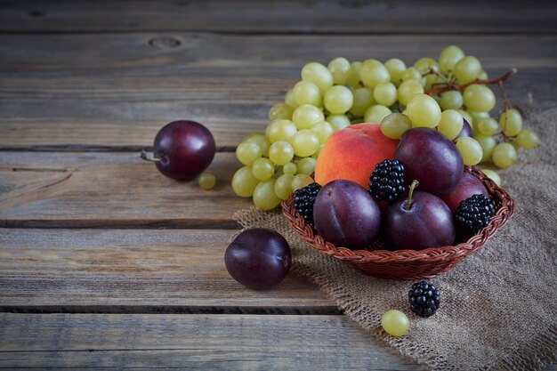 Mischung aus frischen Beeren und Früchten auf rustikalem Holz