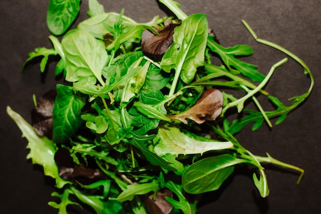 Mischung aus Salatblättern verschiedener Arten auf schwarzem Tisch